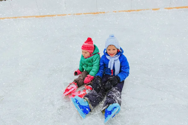 Gelukkig weinig jongen en meisje samen schaatsen — Stockfoto