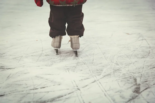 Criança pés aprendendo a patinar no gelo no inverno — Fotografia de Stock