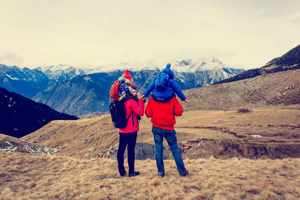 Keluarga dengan dua anak hiking di pegunungan musim dingin — Stok Foto