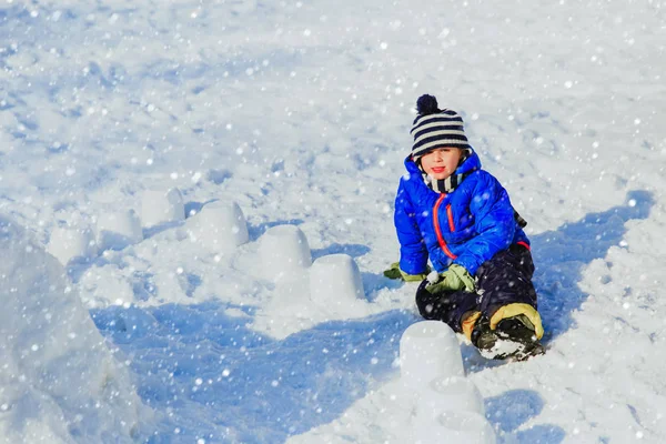 Kleiner Junge baut Burg aus Schnee — Stockfoto