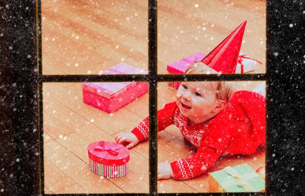 Feliz niña tomando regalos en Navidad, vista desde la ventana exterior — Foto de Stock