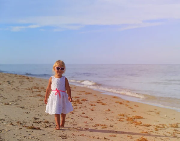 mutlu sevimli küçük kız yürümek kum plaj
