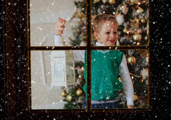 Είδαν το μικρό αγόρι που κατέχουν χριστουγεννιάτικο φανάρι στο σαλόνι από έξω από το παράθυρο — Φωτογραφία Αρχείου