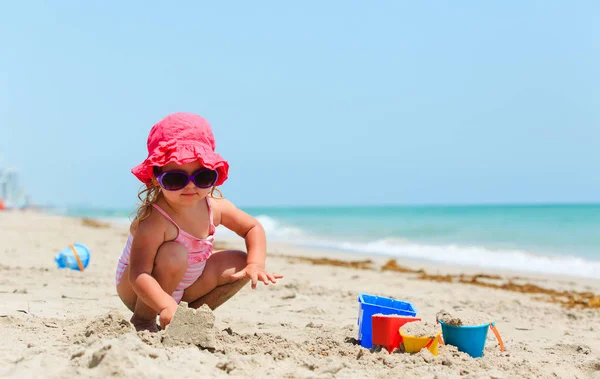 Tatlı küçük kız kumsalda kumla oynuyor. — Stok fotoğraf