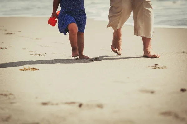 Voet van grootmoeder met meisje lopen op strand — Stockfoto