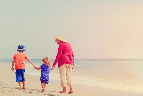 Bonne grand-mère avec des enfants- petit garçon et filles- à la plage — Photo