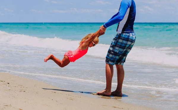 Батько і маленька дочка грають на пляжі — стокове фото