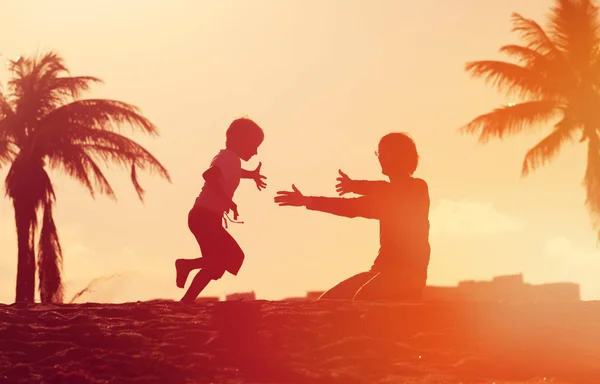 Padre e figlio giocano alla spiaggia al tramonto — Foto Stock