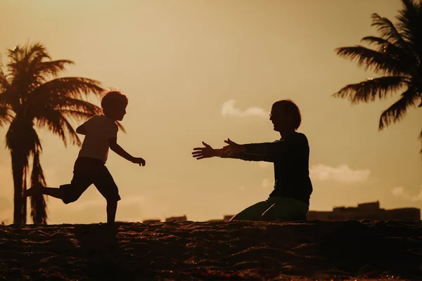 Padre e figlio giocano alla spiaggia al tramonto — Foto Stock