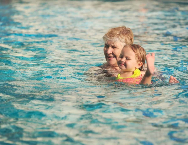 Großmutter und Enkelin schwimmen am Pool — Stockfoto