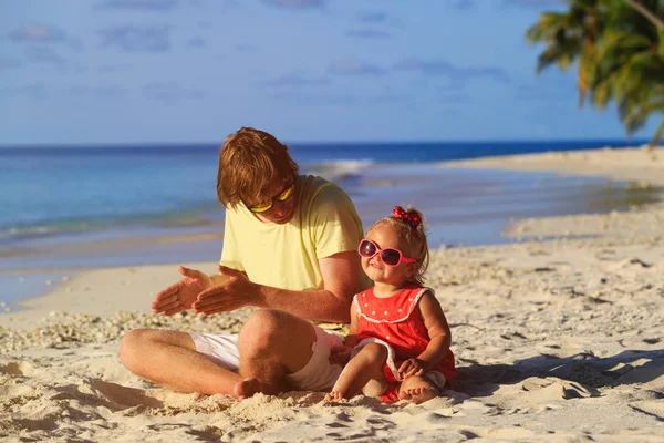 Father and little daughter play at beach — Stock Photo, Image