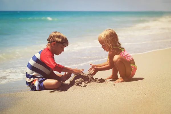 Niños juegan con arena en la playa de verano — Foto de Stock