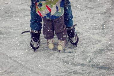 Baba ve küçük kızı kışın paten için öğrenme