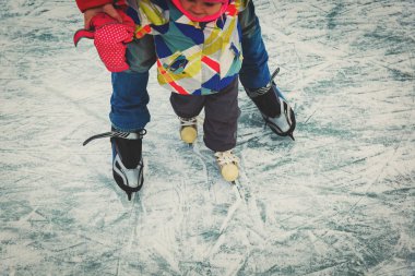 Baba ve küçük kızı kışın paten için öğrenme