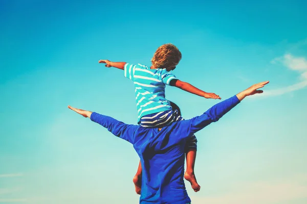 Happy father and son playing on sky — Stock Photo, Image