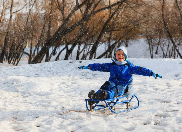 Ευτυχισμένος μικρό αγόρι στο έλκηθρο στο χιόνι το χειμώνα — Φωτογραφία Αρχείου