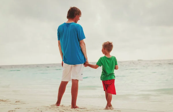 Père et fils tenant la main à la plage — Photo