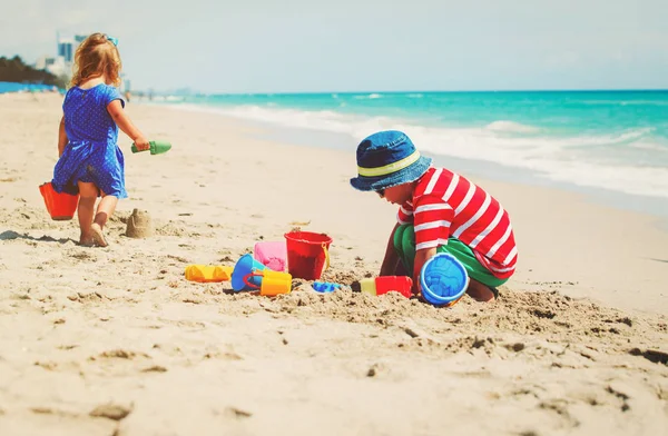 Kinderen spelen met zand op het zomerstrand — Stockfoto