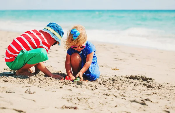 Kinderen spelen met zand op het zomerstrand — Stockfoto