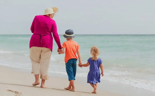 Gelukkig oma met kinderen - kleine jongen en meisje-op strand — Stockfoto