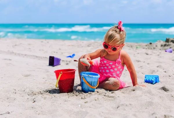 Schattig klein meisje spelen met zand op het strand — Stockfoto