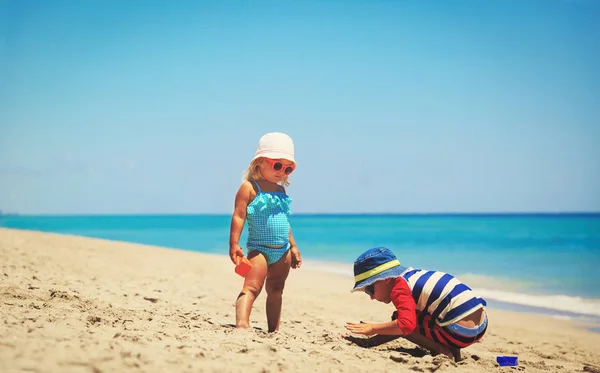 Barn leker med sand på sommaren stranden — Stockfoto