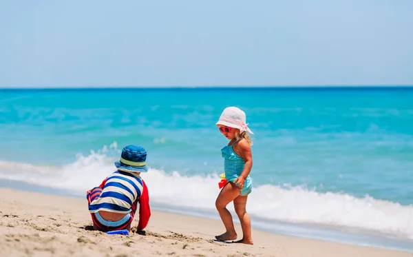 Barn leker med sand på sommaren stranden — Stockfoto