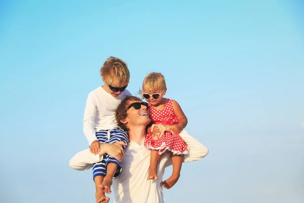 Gelukkig vader met twee kinderen op schouders naar hemel — Stockfoto