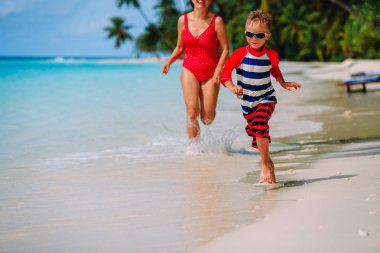 Anne ve oğlu kumsalda suda çalışan