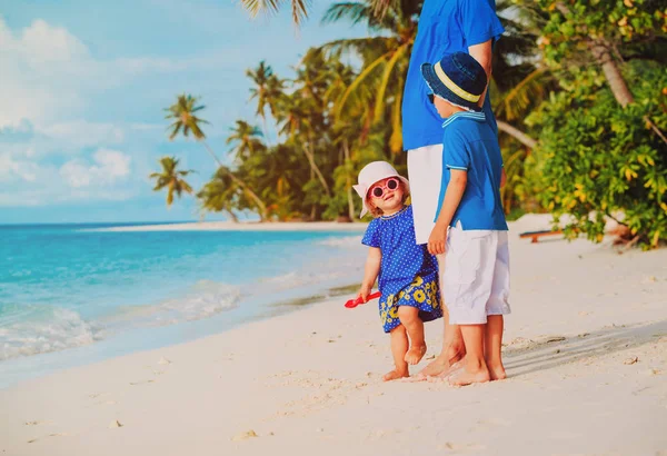 Pai e duas crianças na praia tropical — Fotografia de Stock