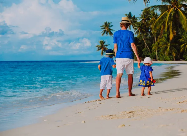 Padre e due bambini a piedi sulla spiaggia estiva — Foto Stock