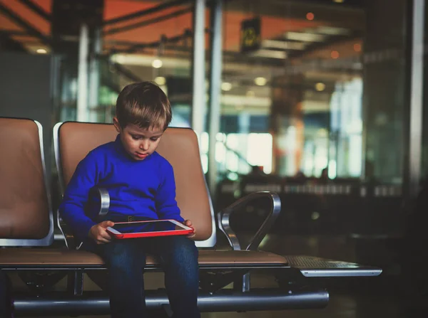 Kleiner Junge schaut auf Touchpad während der Reise im Flughafen — Stockfoto