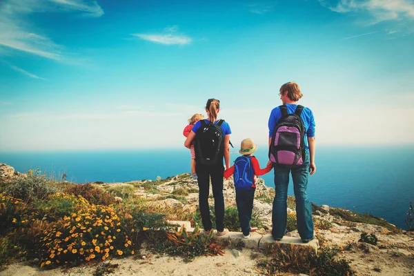 Family with two kids hiking in summer mountains — Stock Photo, Image