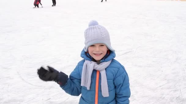 Kleine jongen zeggen Hallo tijdens het schaatsen in de wintersneeuw — Stockvideo