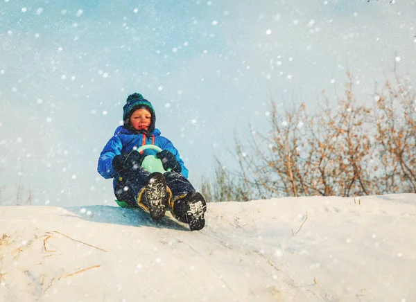 Kinder-Winterspaß - kleiner Junge rutscht im Schnee — Stockfoto