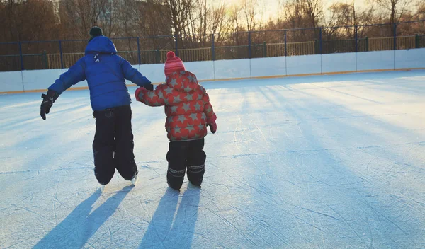 Kis lány és egy fiú larning, télen korcsolyázni — Stock Fotó