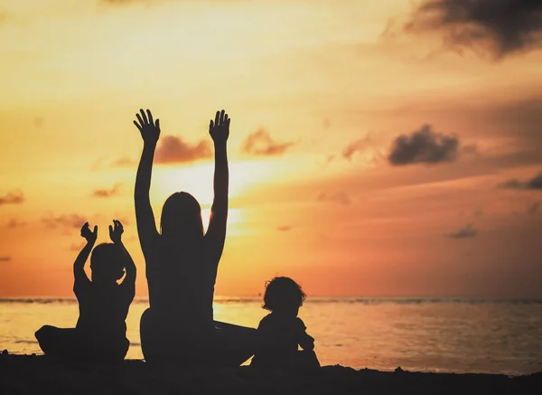 Mãe feliz com dois filhos se divertindo ao pôr do sol — Fotografia de Stock