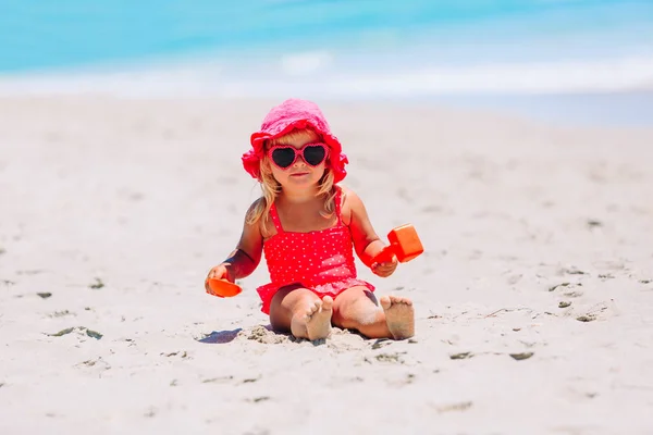 Süßes kleines Mädchen spielt mit Sand am Strand — Stockfoto