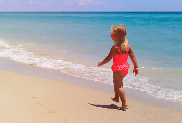 Little girl going to swim at beach — Stock Photo, Image