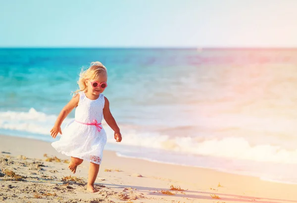 Gelukkig klein meisje lopen op zand strand — Stockfoto