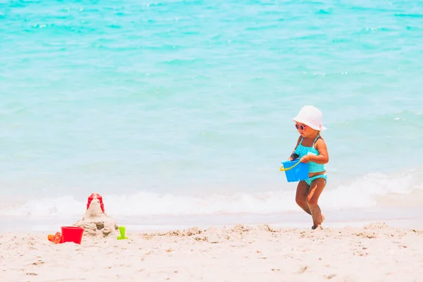 Linda niña jugar con arena en la playa —  Fotos de Stock