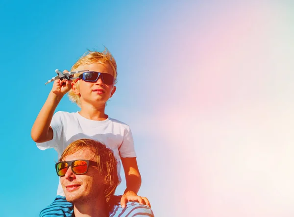 Otec a syn hraje s hračkou letadla na modré obloze — Stock fotografie