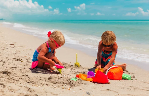 Gyerekek játszanak homokkal a nyári strandon — Stock Fotó