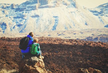 Baba ve oğul dağlarda yürüyüş yapıyor.
