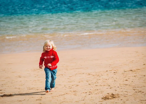 Petite fille mignonne courant sur la plage d'hiver — Photo