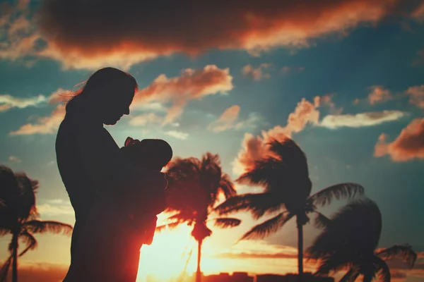 Liefdevolle moeder met baby baby bij zonsondergang tropisch strand — Stockfoto