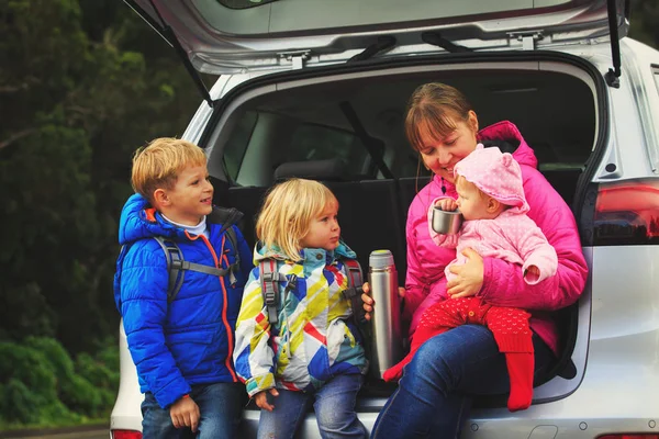 Felice madre con albero i bambini piccoli viaggiano insieme in auto — Foto Stock