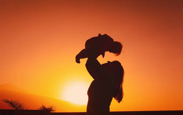 Moeder en kleine baby spelen bij zonsondergang — Stockfoto