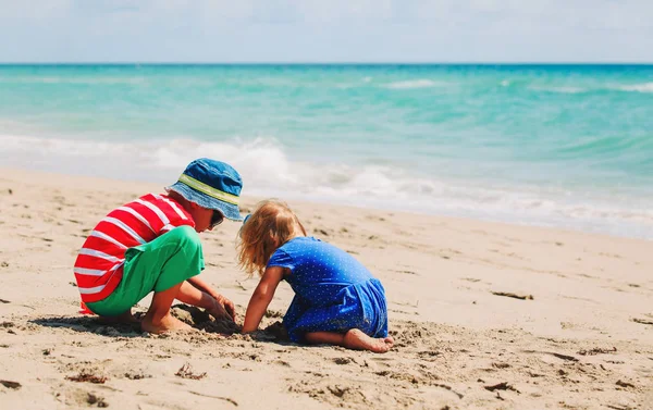 Kids play with sand on summer beach — Stock Photo, Image