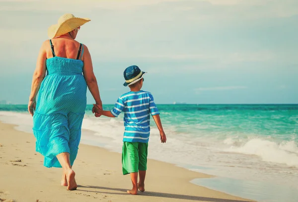 Бабушка и внук прогуливаются по тропическому пляжу — стоковое фото